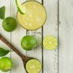 Top view of lime juice with ice on white wood